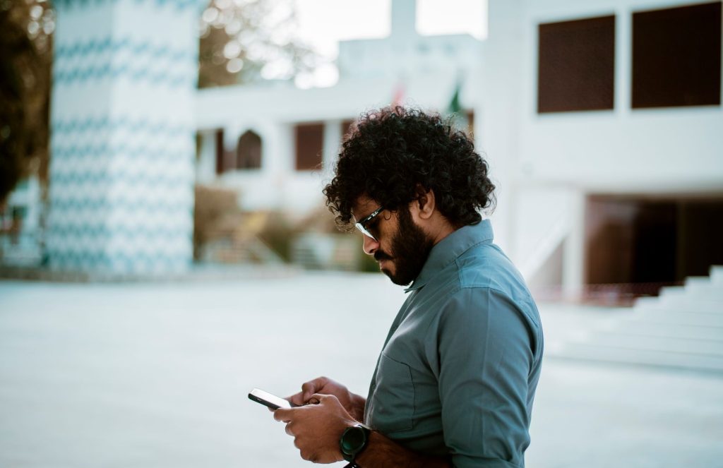 Personne consultant un SMS sur son smartphone dans la rue