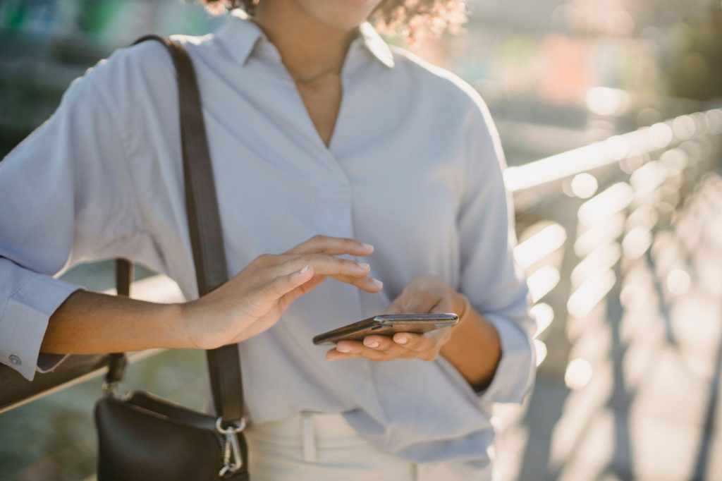 Personne consultant son smartphone en plein soleil pendant une journee de forte chaleur