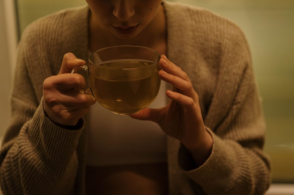 Femme se relaxant le soir avec une tisane, routine du coucher