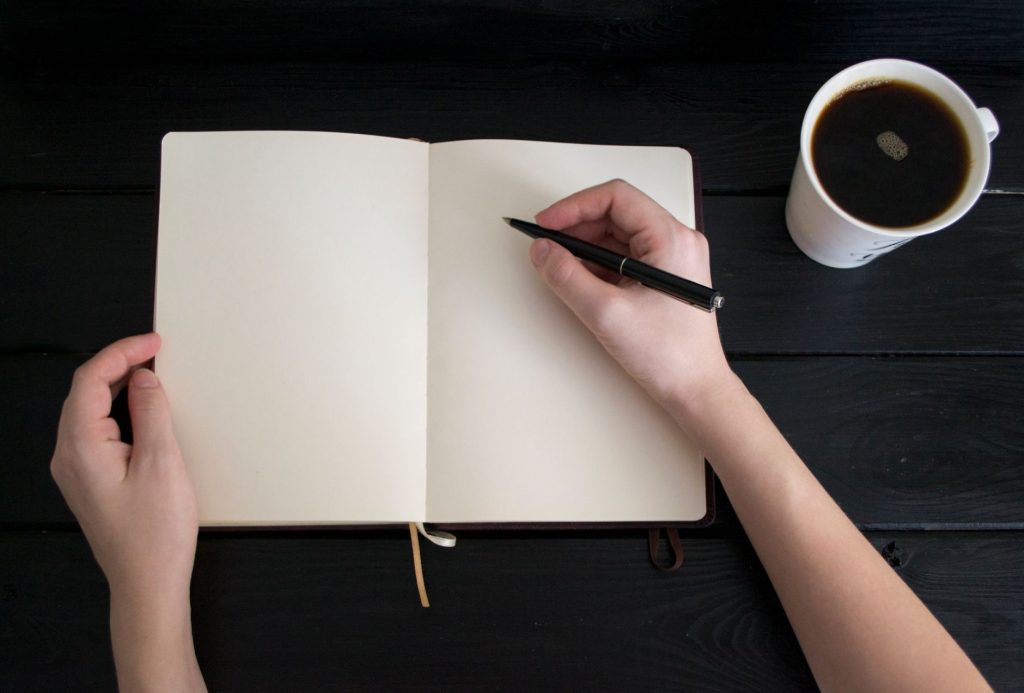 Carnet de notes et café posés sur une table le matin