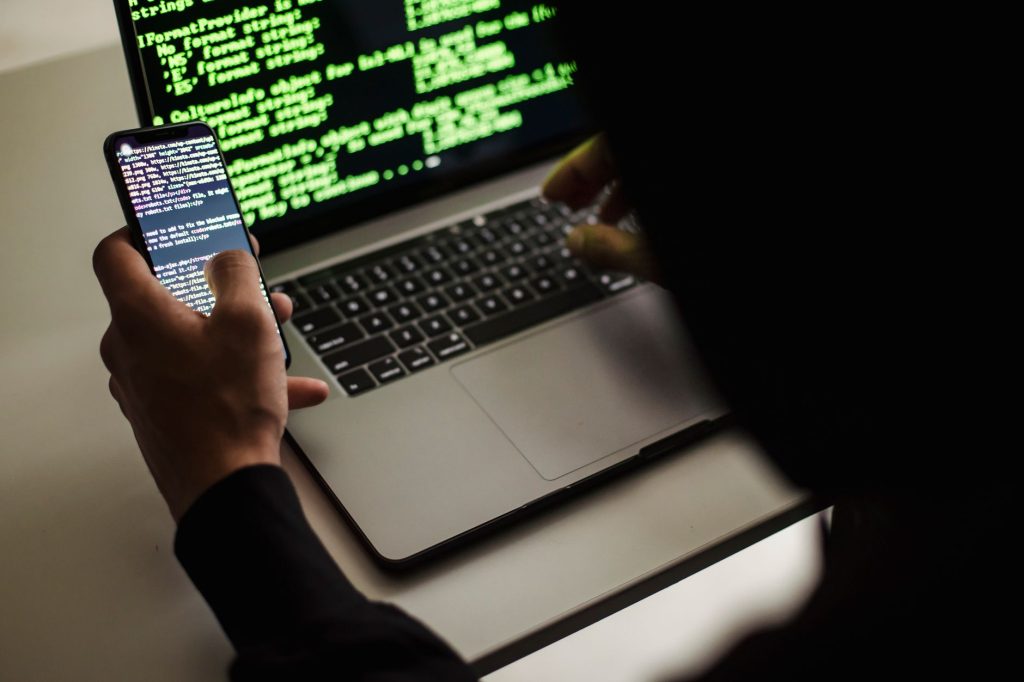 Cybercriminel derrière un ordinateur préparant une attaque de phishing