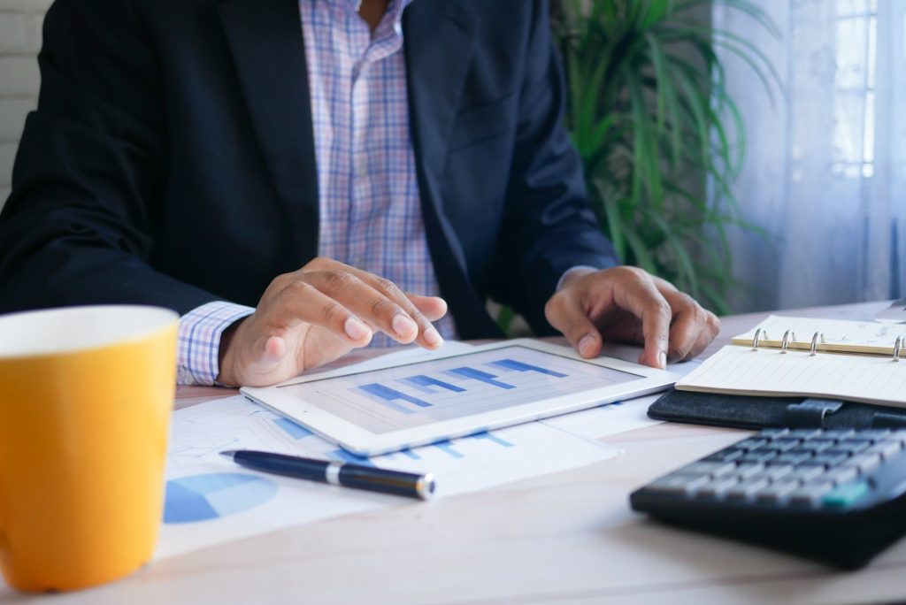 Un entrepreneur analyse des graphiques et des chiffres posés sur un bureau